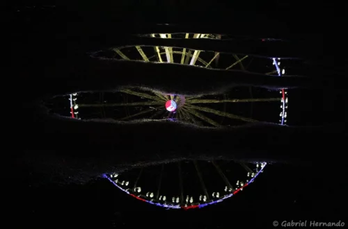 Reflet de la Grande roue de Paris, dans une flaque d'eau